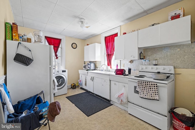 kitchen featuring white cabinetry, white appliances, light countertops, light floors, and washer / dryer