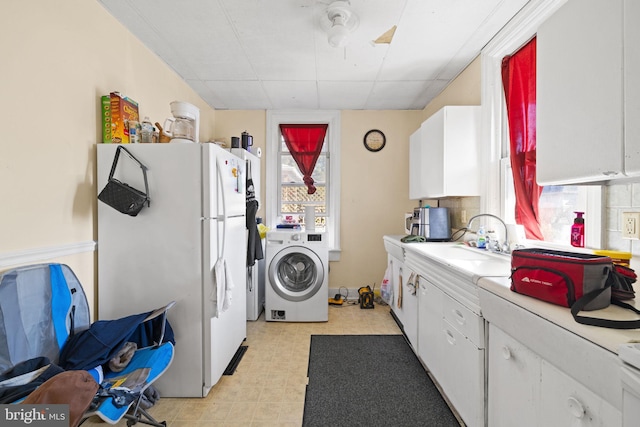 laundry room featuring a sink, washer / clothes dryer, light floors, and laundry area