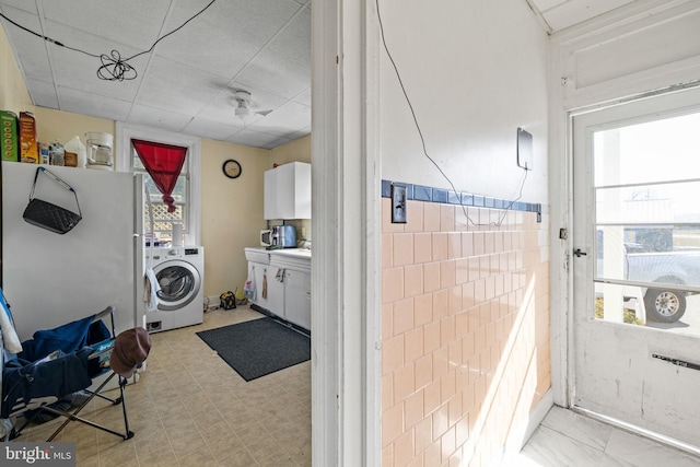 laundry room with washer / clothes dryer, tile walls, and laundry area