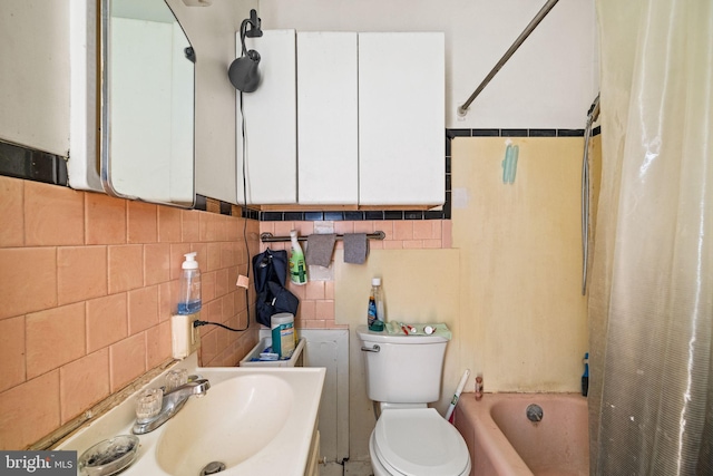 bathroom featuring tasteful backsplash, tile walls, toilet, shower / bath combo with shower curtain, and vanity