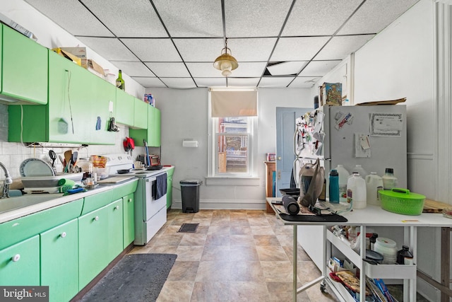 kitchen with white appliances, a paneled ceiling, light countertops, and a sink