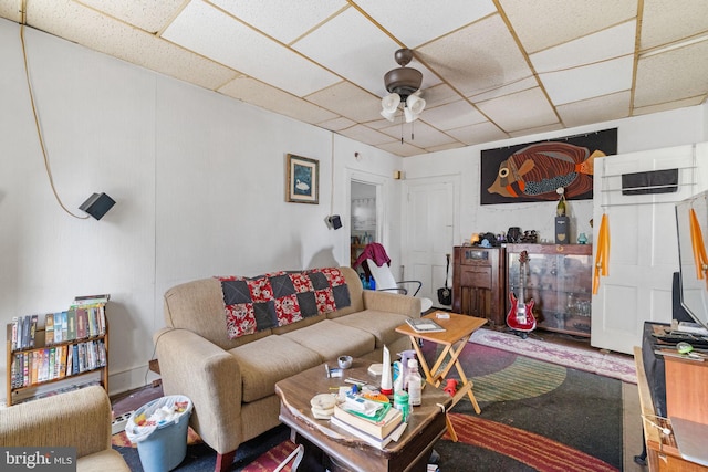 living room featuring a paneled ceiling and ceiling fan