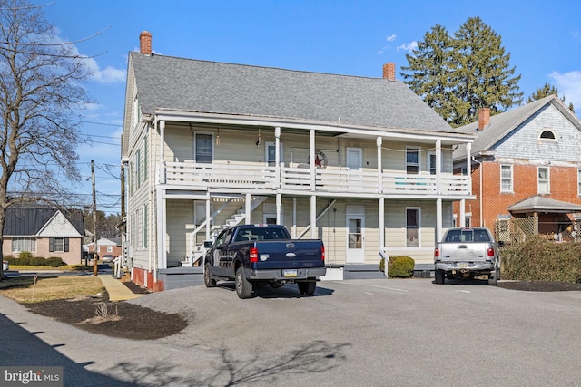 multi unit property with a chimney and a shingled roof