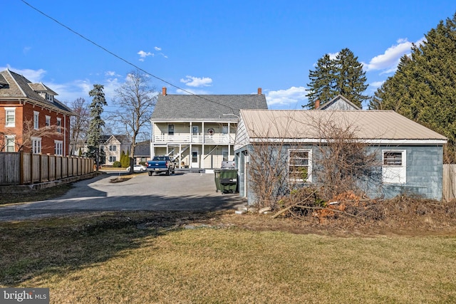 view of home's exterior featuring a yard, a residential view, a balcony, and fence