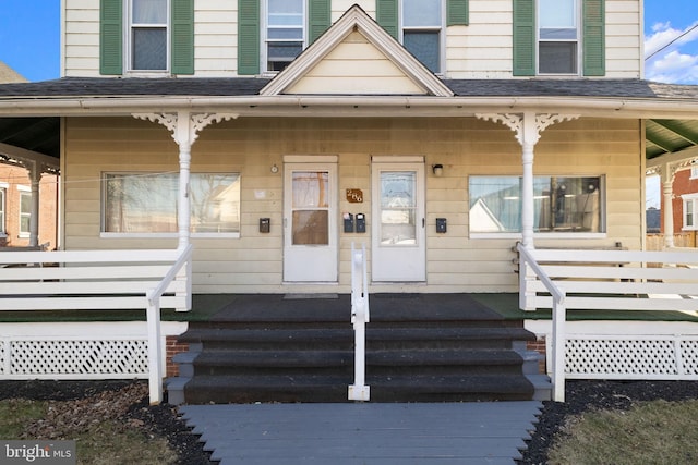 property entrance with a porch and a shingled roof