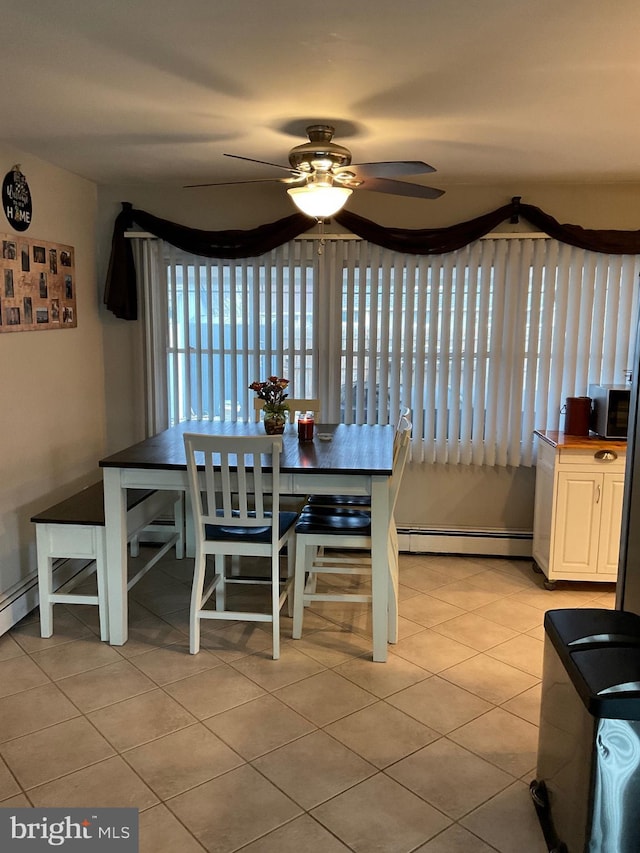 dining space featuring light tile patterned floors, a baseboard radiator, and a ceiling fan