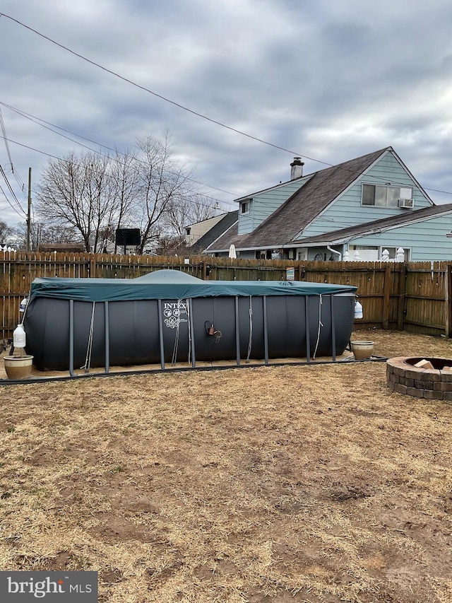 view of yard featuring a fire pit, a fenced backyard, and a fenced in pool