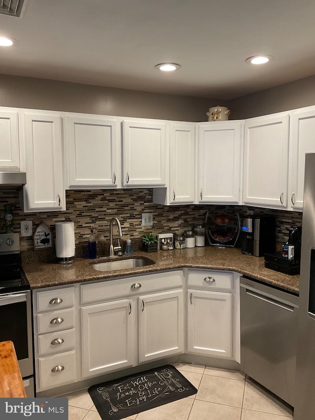 kitchen featuring stainless steel appliances, a sink, and white cabinetry