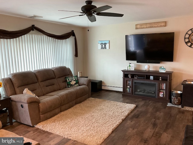 living area featuring a baseboard radiator, a ceiling fan, wood finished floors, and a glass covered fireplace