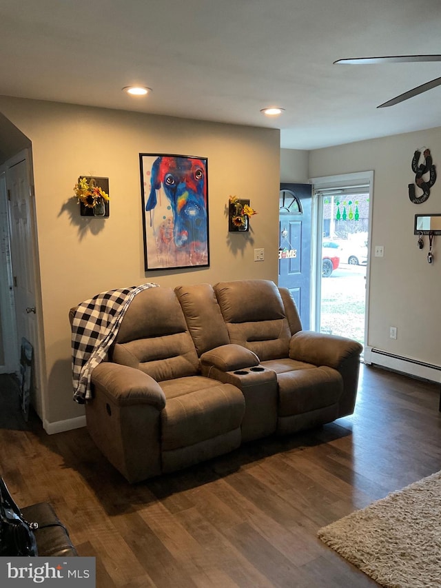 living area with a baseboard heating unit, recessed lighting, baseboards, and wood finished floors