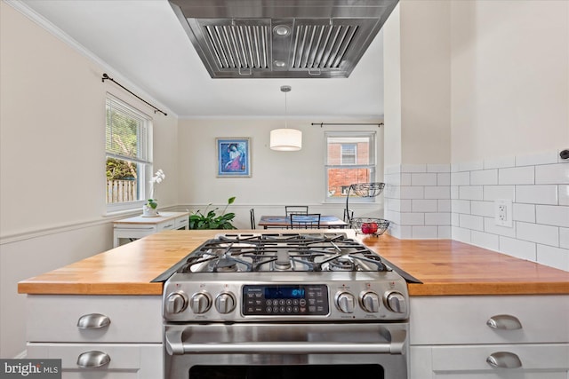 kitchen featuring butcher block countertops, a wealth of natural light, stainless steel gas range oven, and range hood