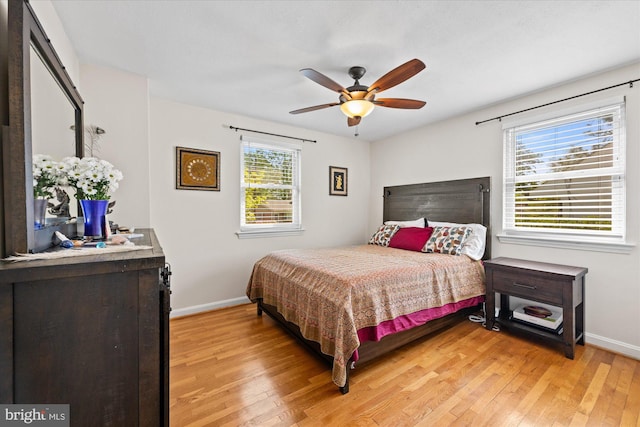 bedroom featuring baseboards, light wood finished floors, and ceiling fan