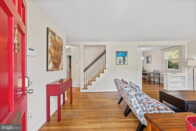 entrance foyer featuring light wood-type flooring, baseboards, and stairway