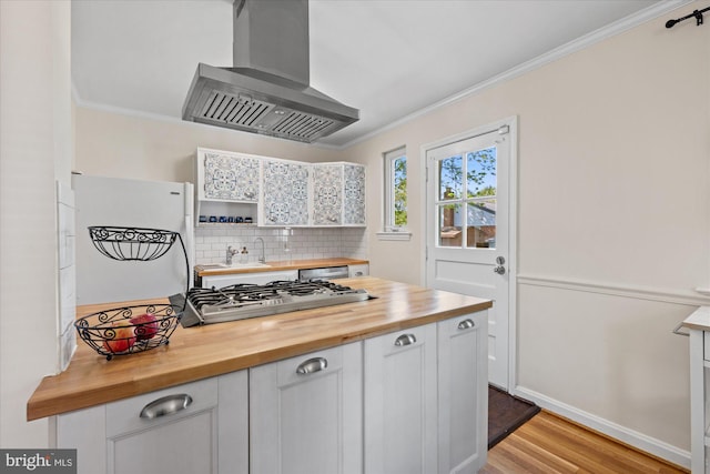kitchen featuring tasteful backsplash, stainless steel gas cooktop, wood counters, ornamental molding, and wall chimney exhaust hood