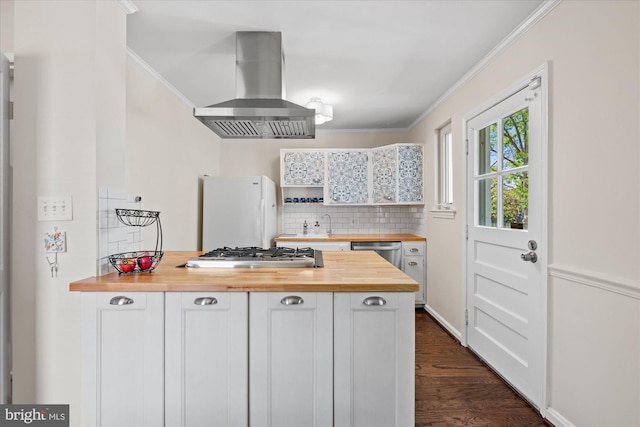 kitchen featuring butcher block countertops, crown molding, appliances with stainless steel finishes, and island range hood