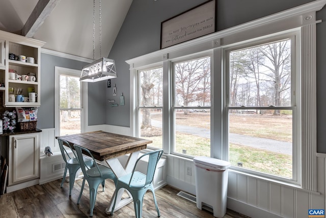 dining area featuring plenty of natural light, visible vents, vaulted ceiling, and wood finished floors