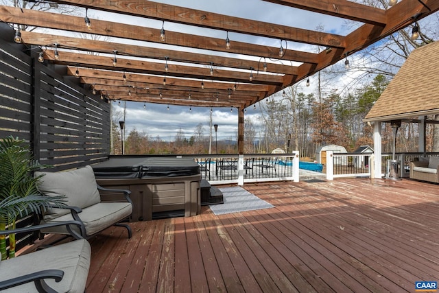 wooden deck with a hot tub, a pergola, and an outdoor structure