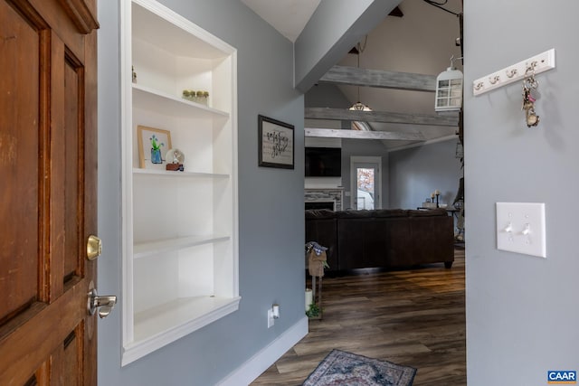 foyer with dark wood-type flooring, a fireplace, and baseboards