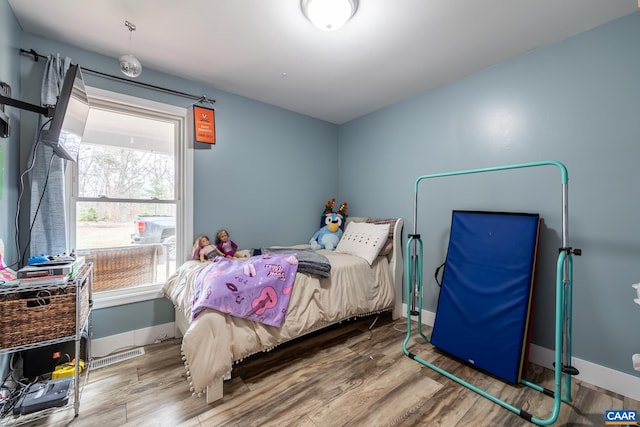 bedroom featuring baseboards and wood finished floors