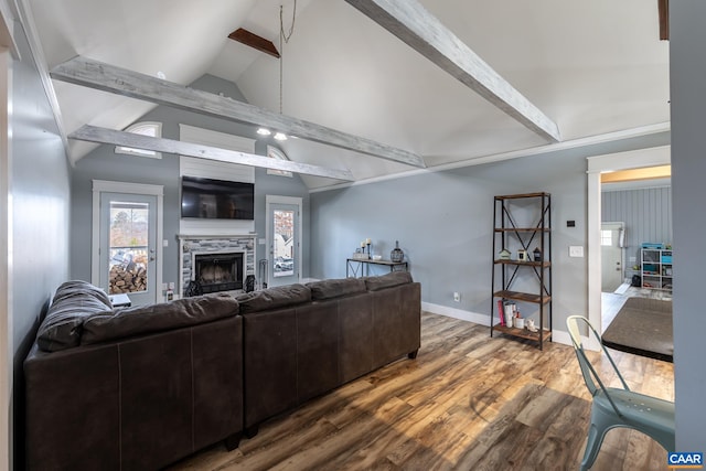 living room with a fireplace, lofted ceiling with beams, baseboards, and wood finished floors