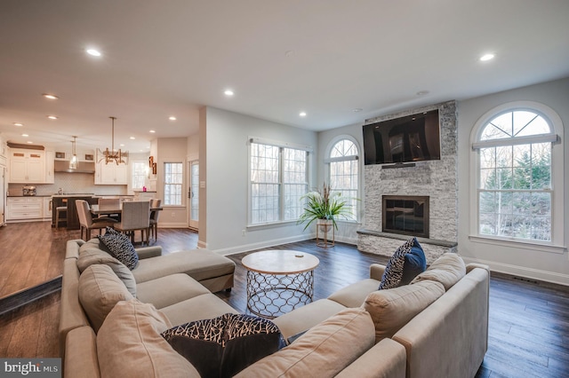 living room with a fireplace, plenty of natural light, dark wood-style floors, and recessed lighting