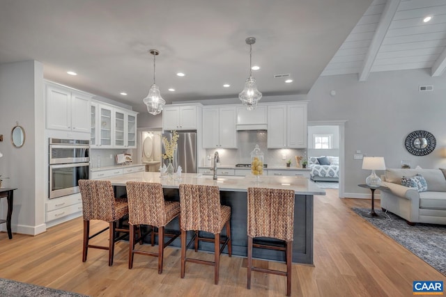 kitchen with white cabinetry, appliances with stainless steel finishes, light countertops, and decorative backsplash