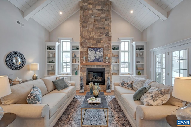 living area featuring a stone fireplace, wood finished floors, wood ceiling, visible vents, and beamed ceiling