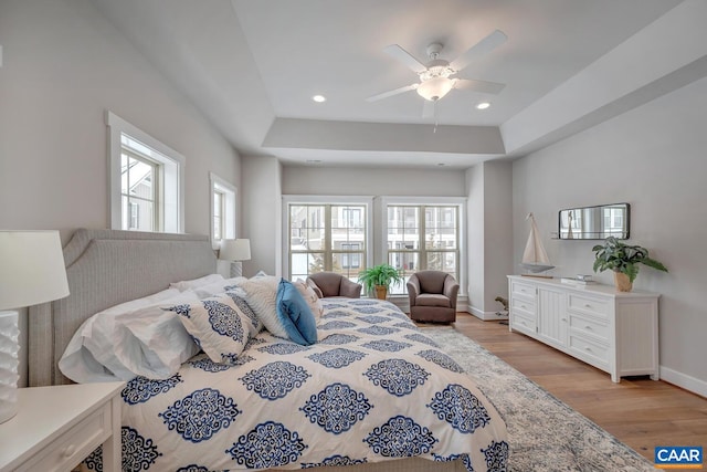 bedroom with ceiling fan, recessed lighting, baseboards, light wood finished floors, and a raised ceiling