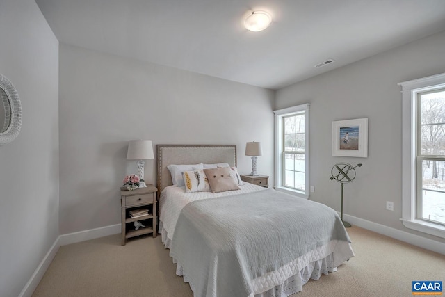 bedroom with light carpet, multiple windows, and visible vents