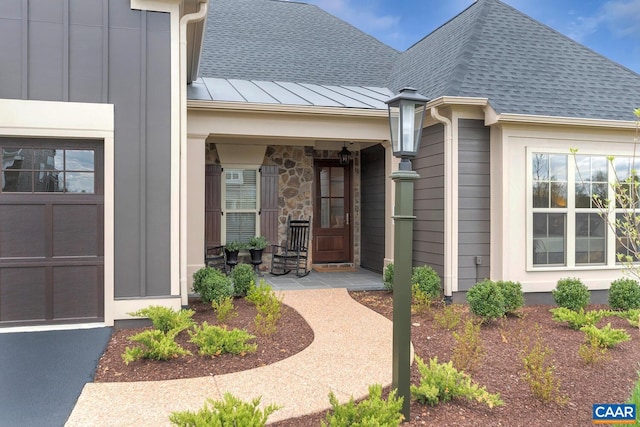 entrance to property with stone siding, a porch, and roof with shingles