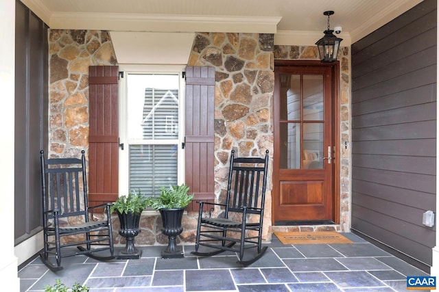 doorway to property featuring stone siding and a porch