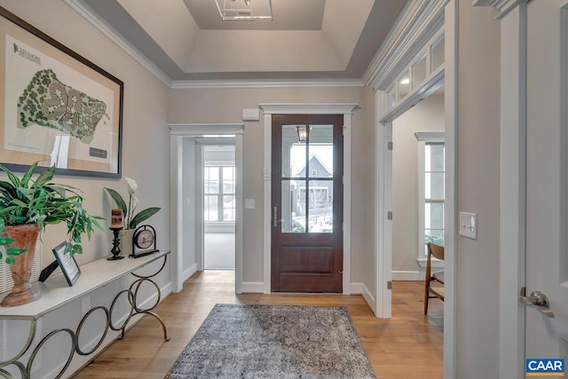 entrance foyer featuring light wood-style flooring, baseboards, and a raised ceiling