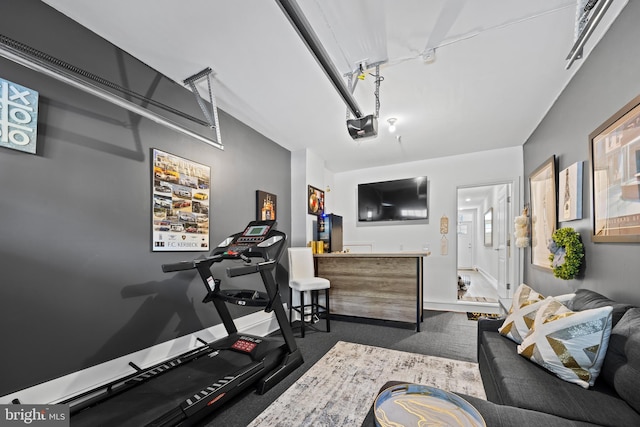 exercise room featuring baseboards and a garage