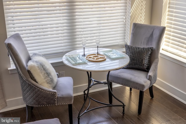 dining area with baseboards and wood finished floors