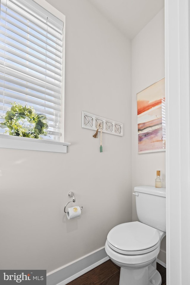 bathroom featuring baseboards, toilet, and wood finished floors