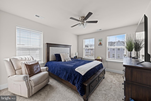 bedroom featuring visible vents, light colored carpet, baseboards, and ceiling fan