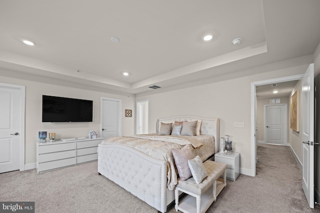 bedroom with recessed lighting, visible vents, light colored carpet, and a raised ceiling