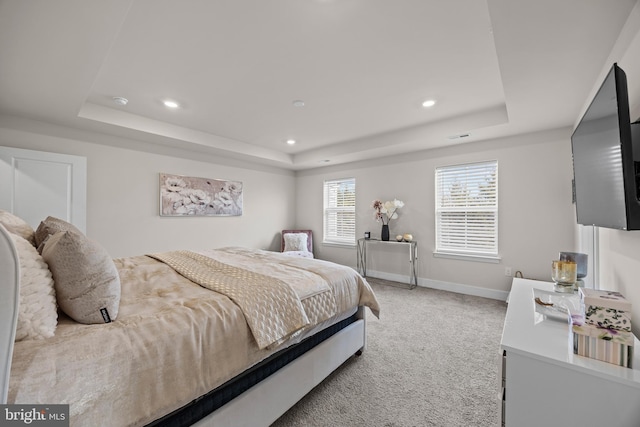 bedroom with visible vents, baseboards, light colored carpet, a tray ceiling, and recessed lighting