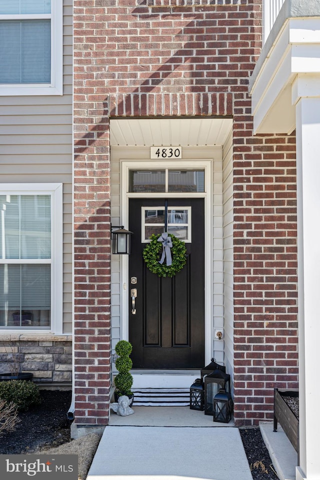 view of exterior entry featuring brick siding