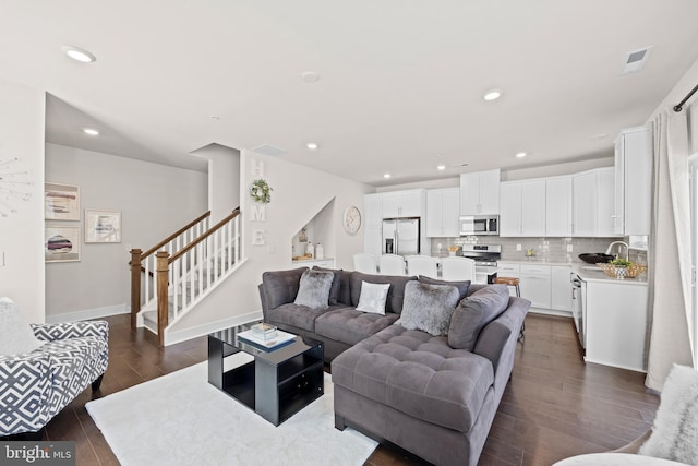 living area featuring visible vents, dark wood-style floors, recessed lighting, stairway, and baseboards