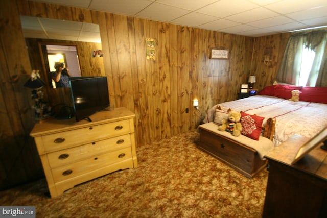 bedroom featuring carpet floors and wood walls