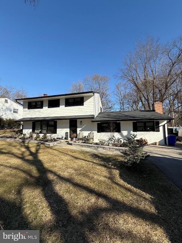 view of front of house featuring a front yard and a chimney