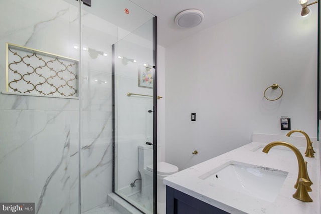 bathroom with a sink, a marble finish shower, toilet, and double vanity