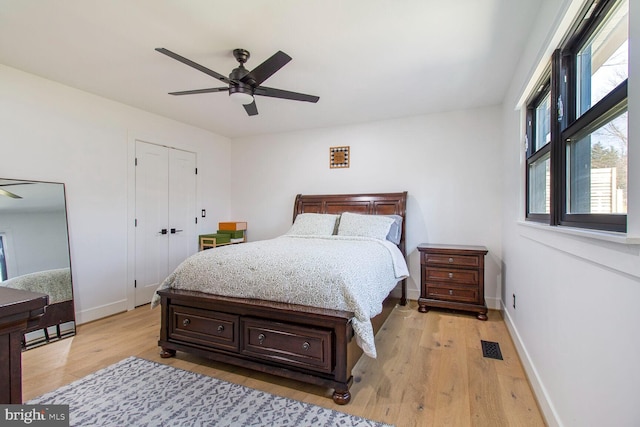 bedroom featuring visible vents, baseboards, a ceiling fan, and light wood finished floors