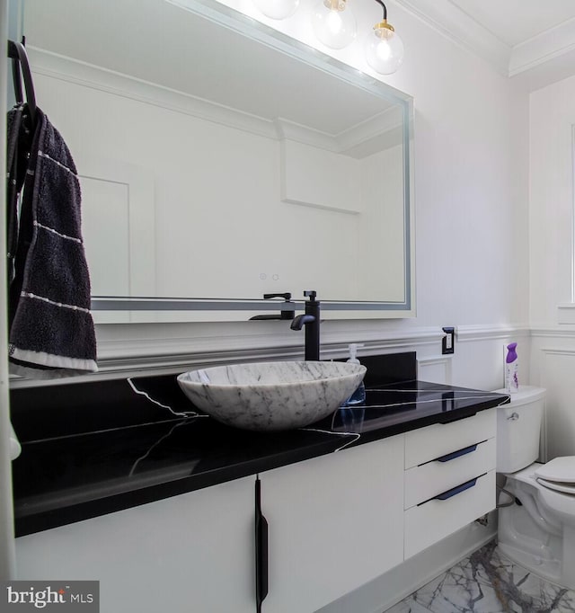 half bath featuring vanity, a wainscoted wall, crown molding, toilet, and marble finish floor