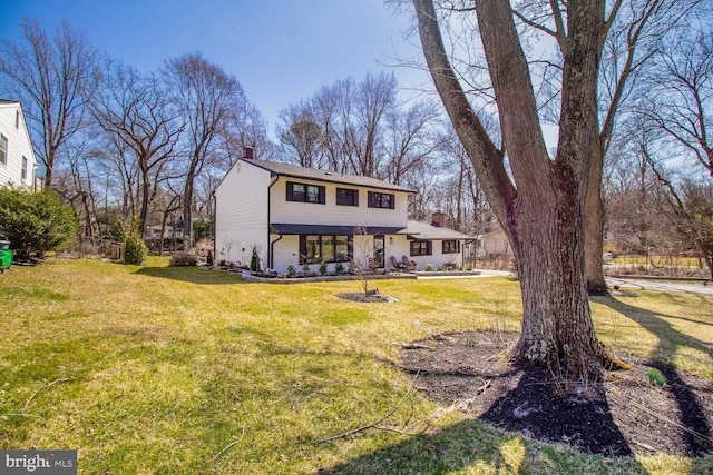 view of front of home featuring a chimney and a front yard