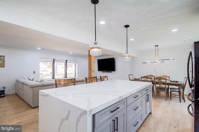 kitchen with light wood-type flooring, open floor plan, a center island, freestanding refrigerator, and recessed lighting