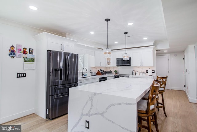 kitchen featuring white cabinets, stainless steel appliances, crown molding, and a sink