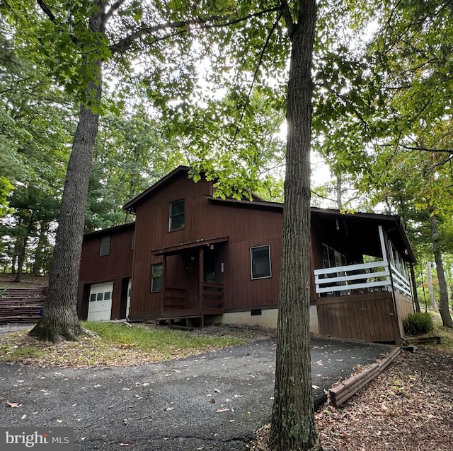 view of property exterior with covered porch, crawl space, and an attached garage