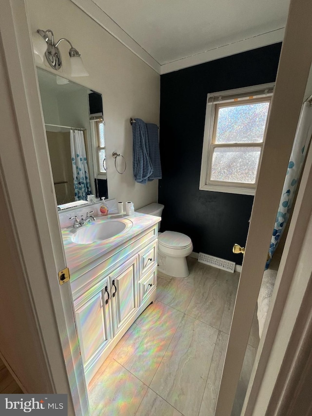 full bath featuring visible vents, toilet, ornamental molding, vanity, and baseboards